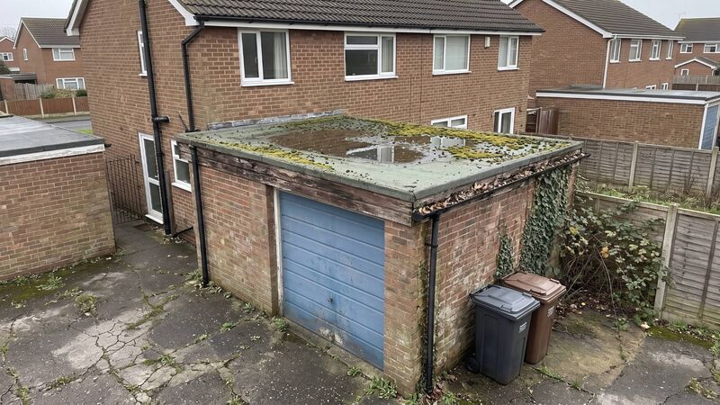 Old flat roof with moss and ponding water before repair