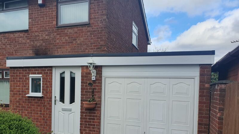 Garage flat roof replacement with new white fascia on a UK home